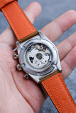 Underside view of the brown leather strap with matching orange leather-backing